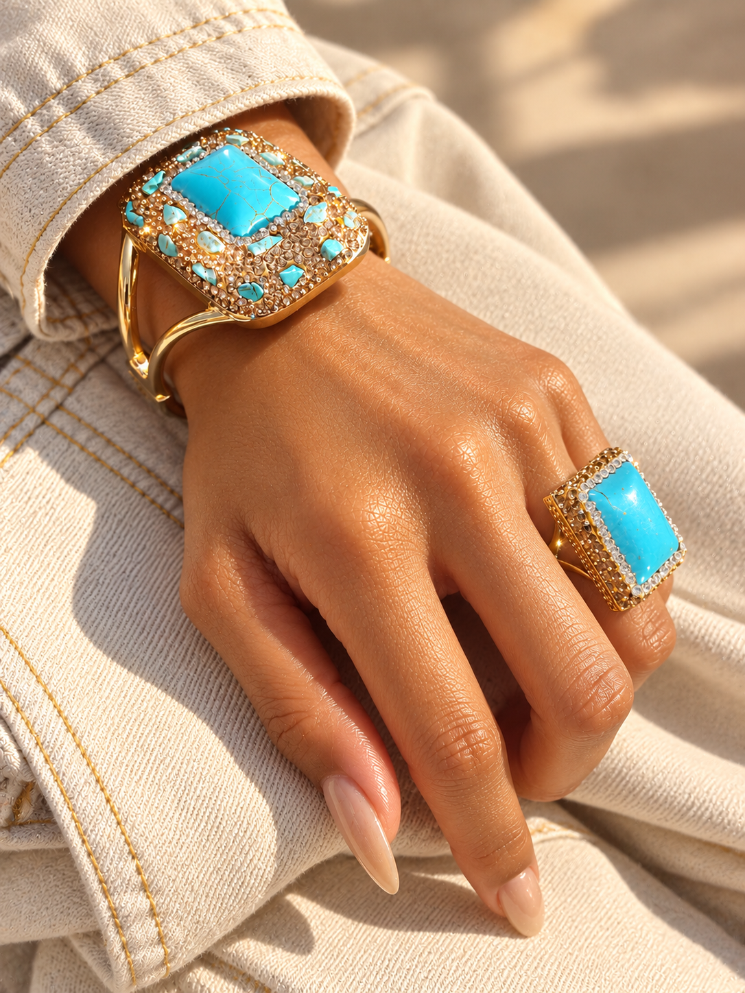 Bague Horizon Rectangle Bleu — Bague portée vue de trois-quarts, cabochon rectangulaire bleu veiné, entourage brillant clair et monture dorée ; bracelet également visible au poignet.
