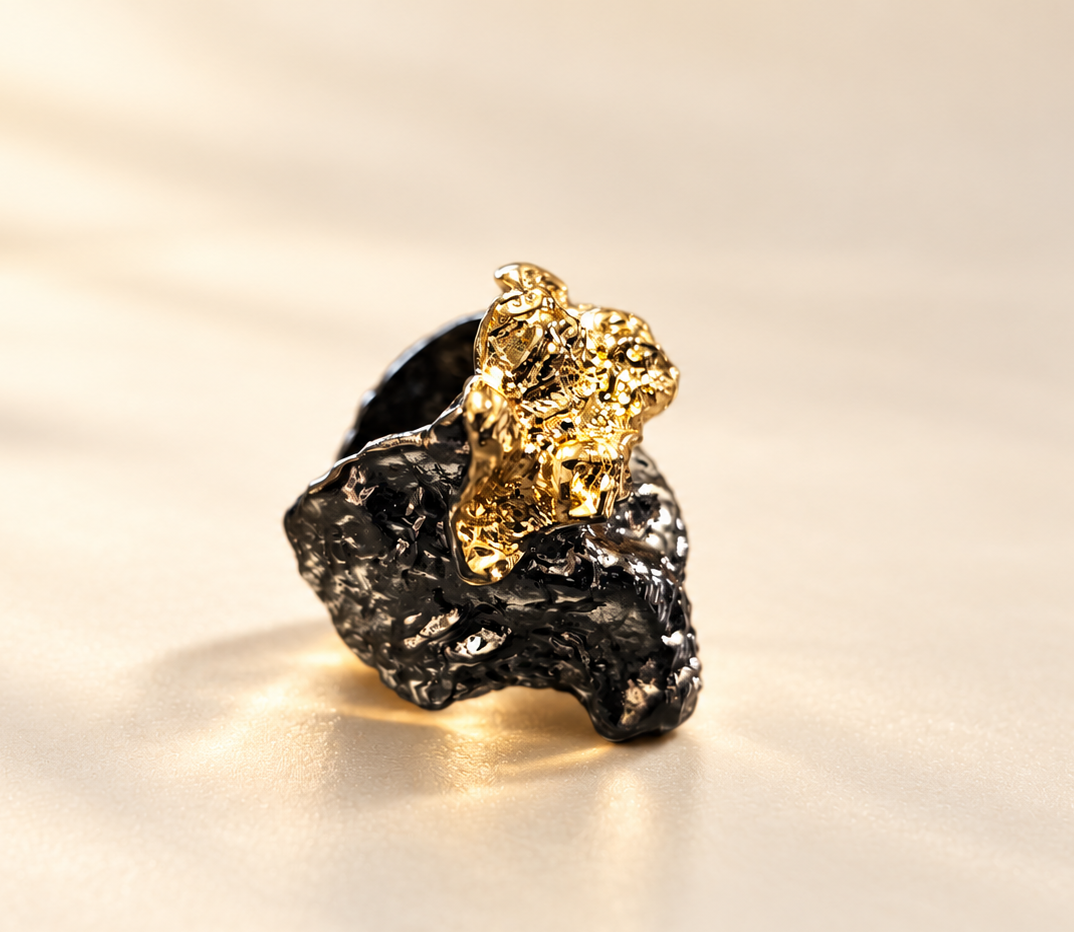 Bague Tellure Relief Noir & Doré — Bague seule de trois-quarts sur fond clair, base noire brillante aux contours irréguliers et relief doré saillant à la texture plissée.