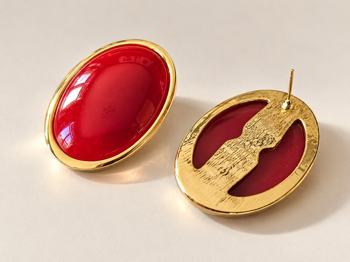 Boucles d’oreilles Flamme Ovales Rouges & Doré — Une boucle présentée de face et l’autre retournée, montrant un dos doré texturé à deux ouvertures et une tige apparente.