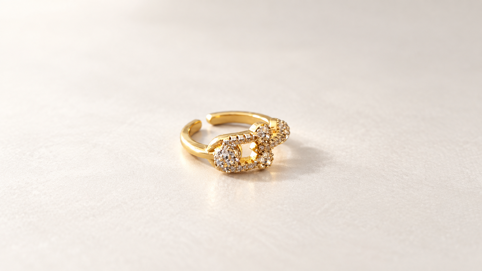 Bague Cadence Maillons Dorés — Bague dorée vue de trois-quarts depuis la gauche, montrant le côté lisse de l’anneau et les contours ajourés ornés de petits éléments clairs.