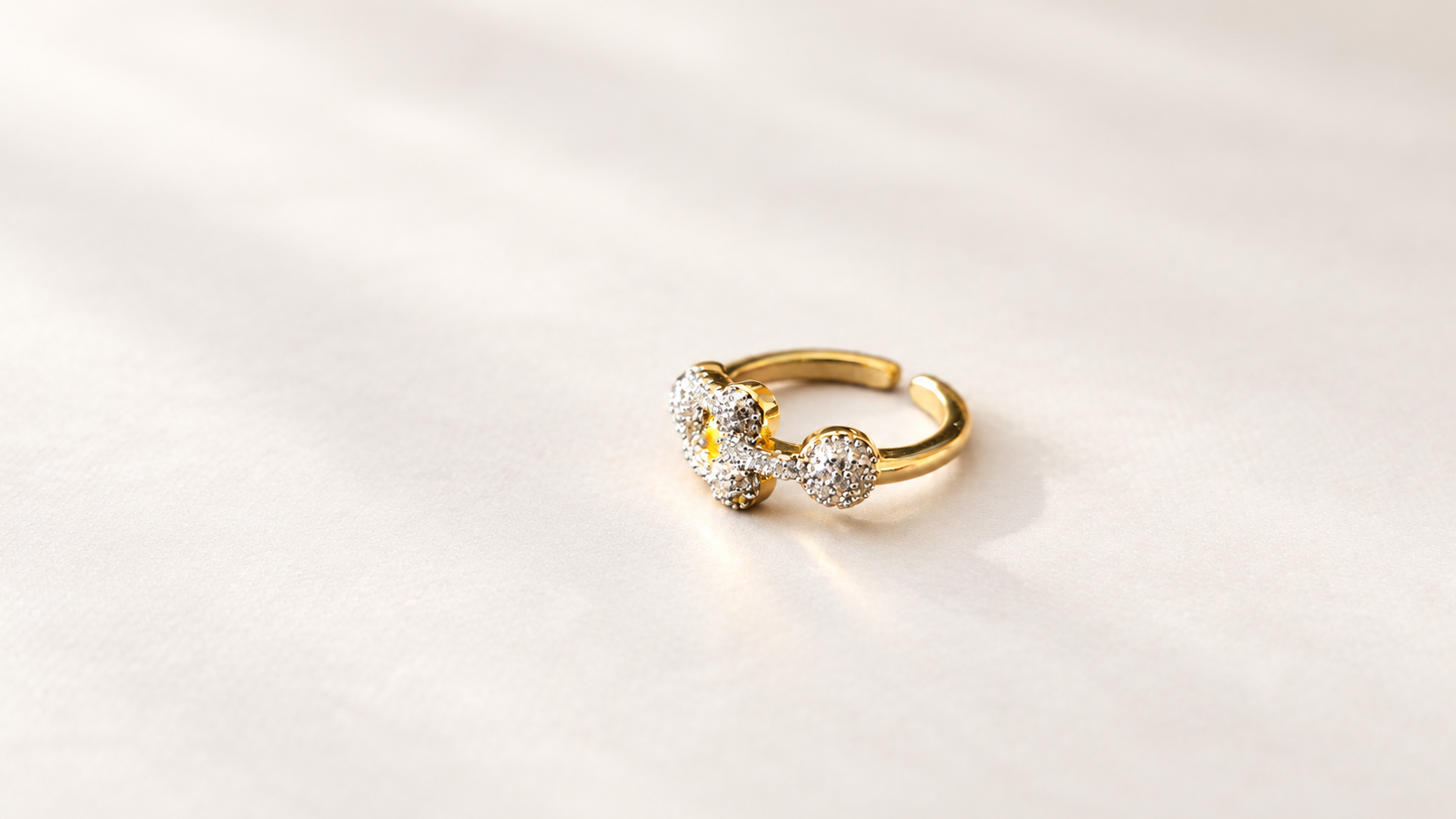 Bague Cadence Maillons Dorés — Bague dorée vue de trois-quarts depuis la droite, avec formes circulaires en relief, éléments brillants clairs et anneau ouvert en arrière-plan.
