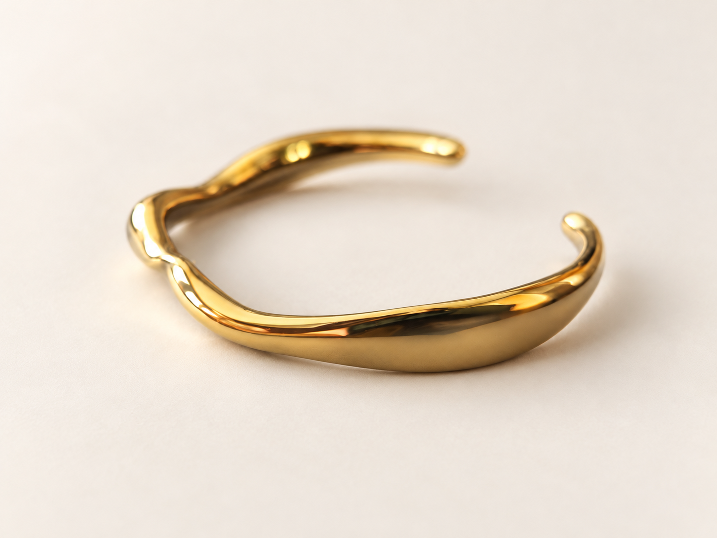 Bracelet Jonc Sillage Doré — Jonc doré sous un autre angle oblique, volume arrondi au premier plan et inflexions du contour sur la gauche.