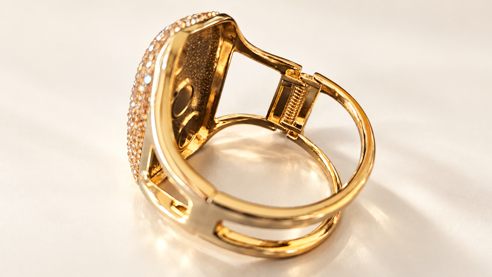 Parure Incandescence Rouge — Vue rapprochée de l’intérieur du bracelet, montrant le ressort latéral doré et l’articulation reliant les lignes arrondies aux côtés ajourés.