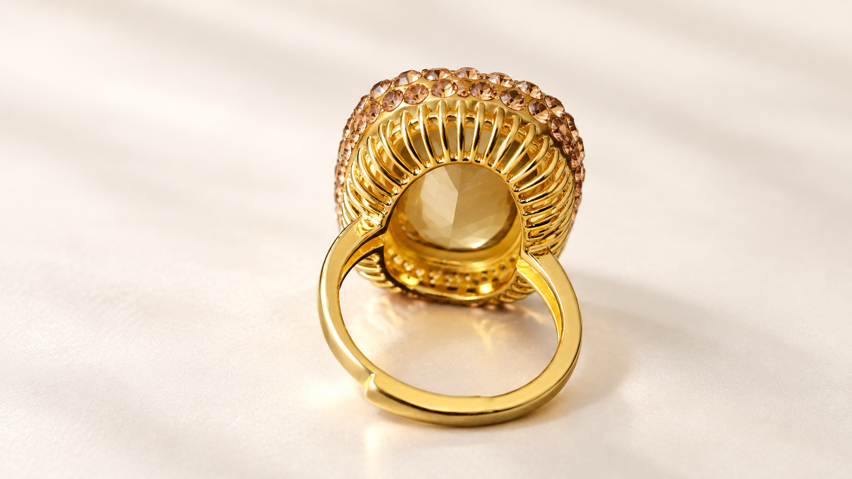 Parure Incandescence Rouge — Arrière de la bague dorée, montrant les ouvertures verticales de la monture, le dessous du motif central et les extrémités ouvertes de l’anneau.