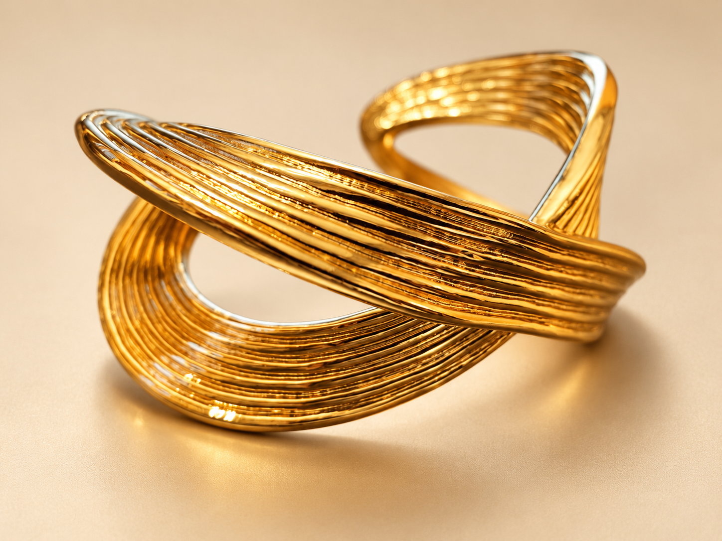 Bracelet Manchette Sillage Croisé Doré — Manchette dorée de trois-quarts, bande oblique au premier plan et grande ouverture arrondie sous le croisement.