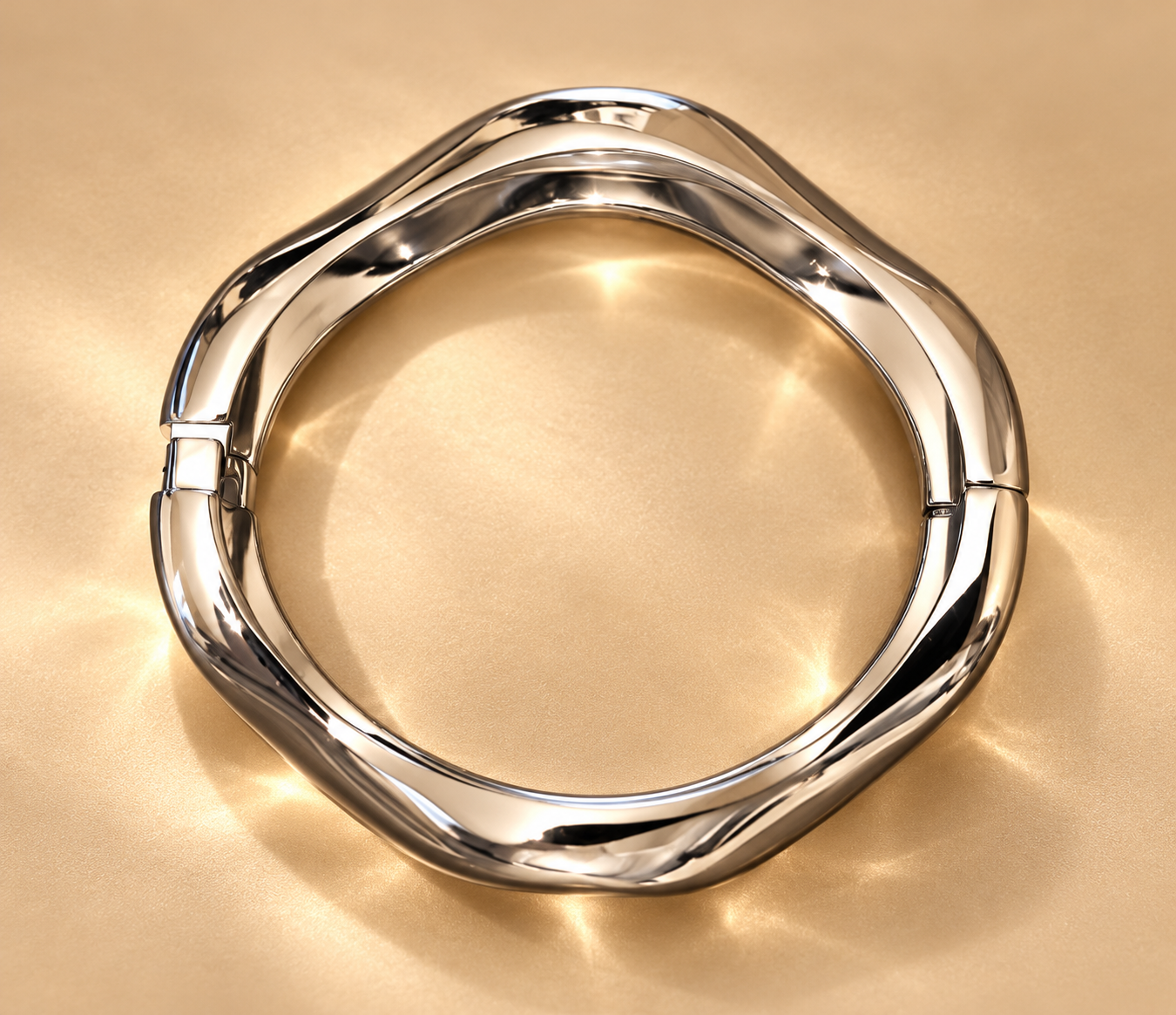Bracelet Sillage Ondulé Argenté — Bracelet argenté vu de dessus, montrant son contour irrégulier fermé et les jonctions latérales sur un fond doré.