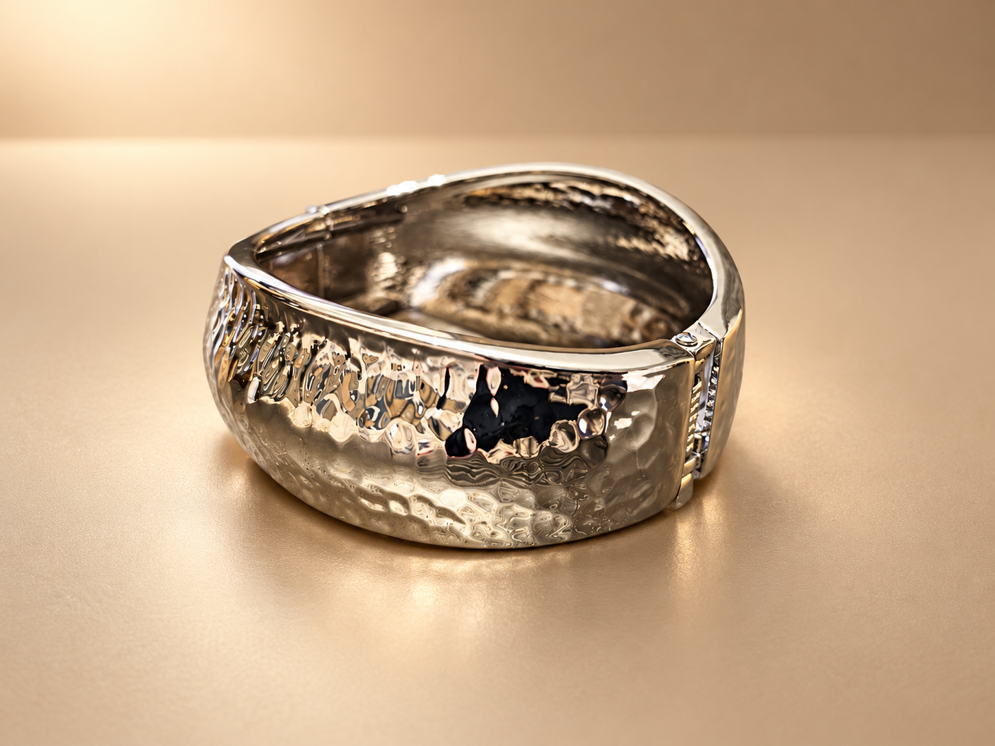 Bracelet Manchette Sillage Martelé — Argenté — Vue oblique de la manchette argenté avec articulation sur le côté droit et relief brillant sur la face extérieure.