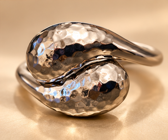 Bracelet Duo Galet — Argenté — Bracelet vu de face en gros plan, avec deux extrémités bombées à surface martelée qui se croisent et des branches lisses brillantes.