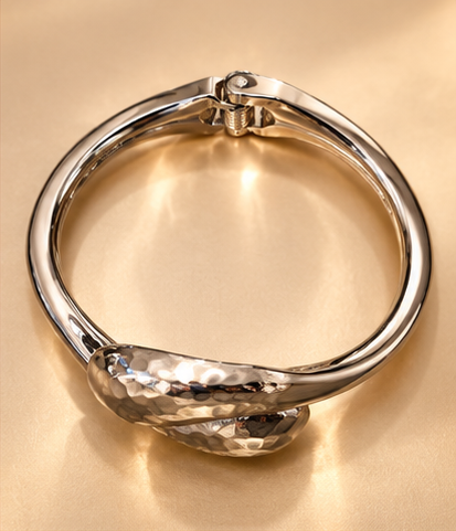 Bracelet Duo Galet — Argenté — Bracelet vu de dessus montrant son contour arrondi, les extrémités croisées au premier plan et l’articulation à ressort à l’opposé.