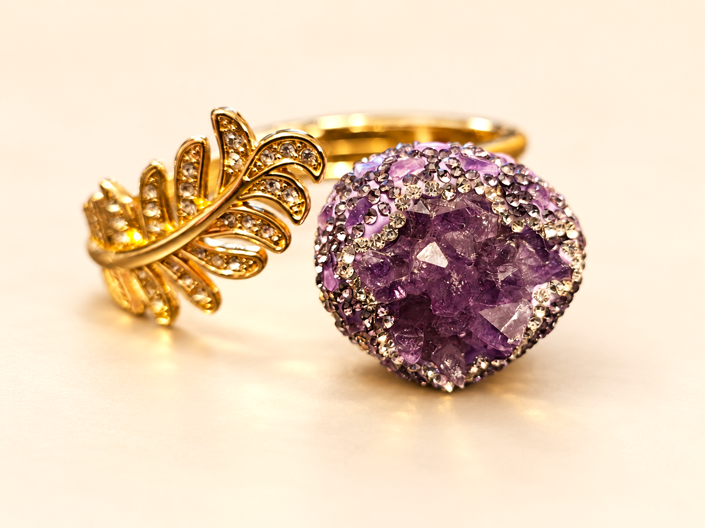 Bracelet de la parure Vesper Ovale Violette — Détail d’un bracelet avec un motif feuillage doré ajouré et un décor arrondi aux fragments violets, bordé de petits éléments brillants.