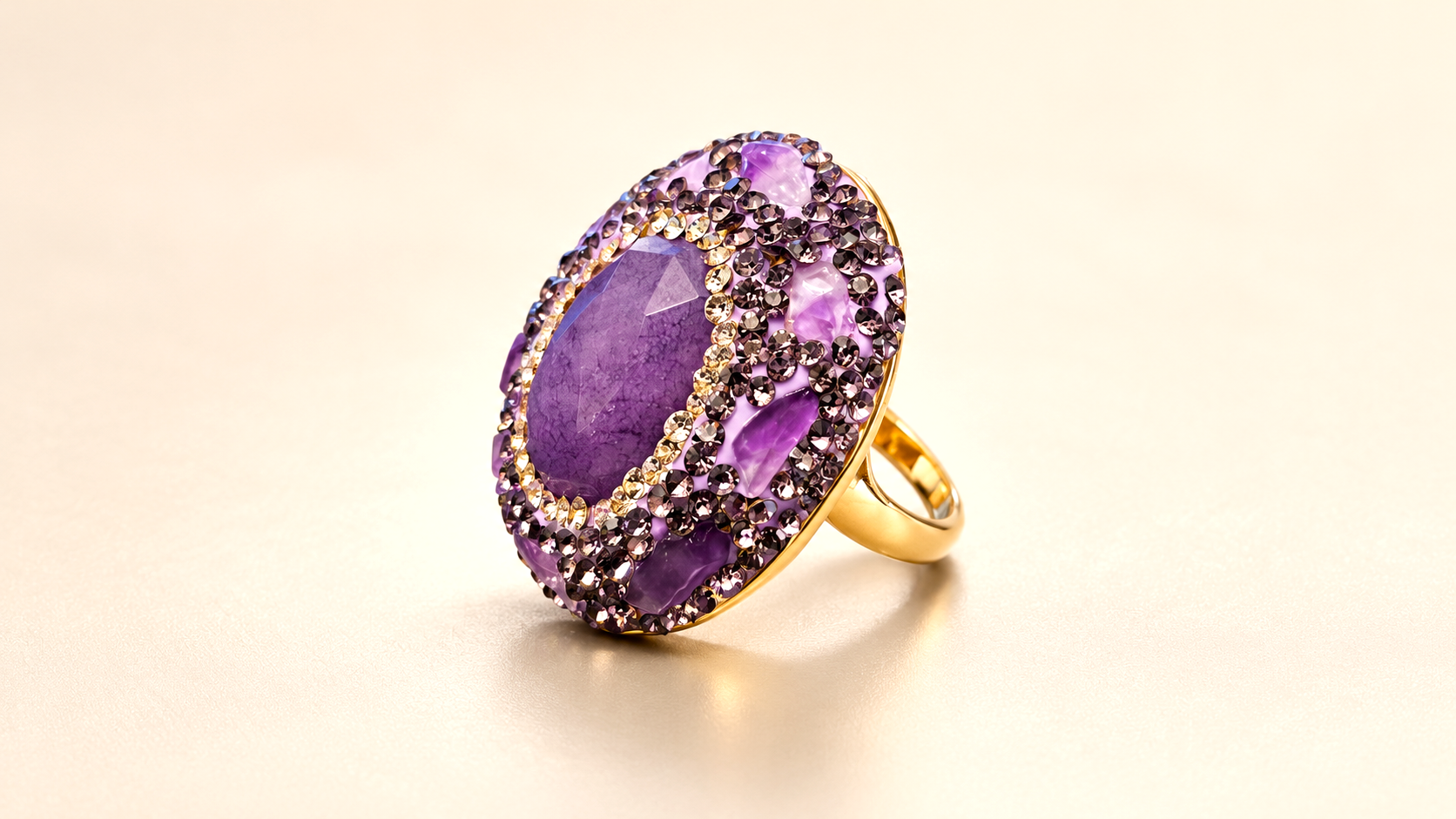 Bague de la parure Vesper Ovale Violette — Bague ovale inclinée de trois-quarts, décor violet en relief et anneau à finition dorée visible à droite.