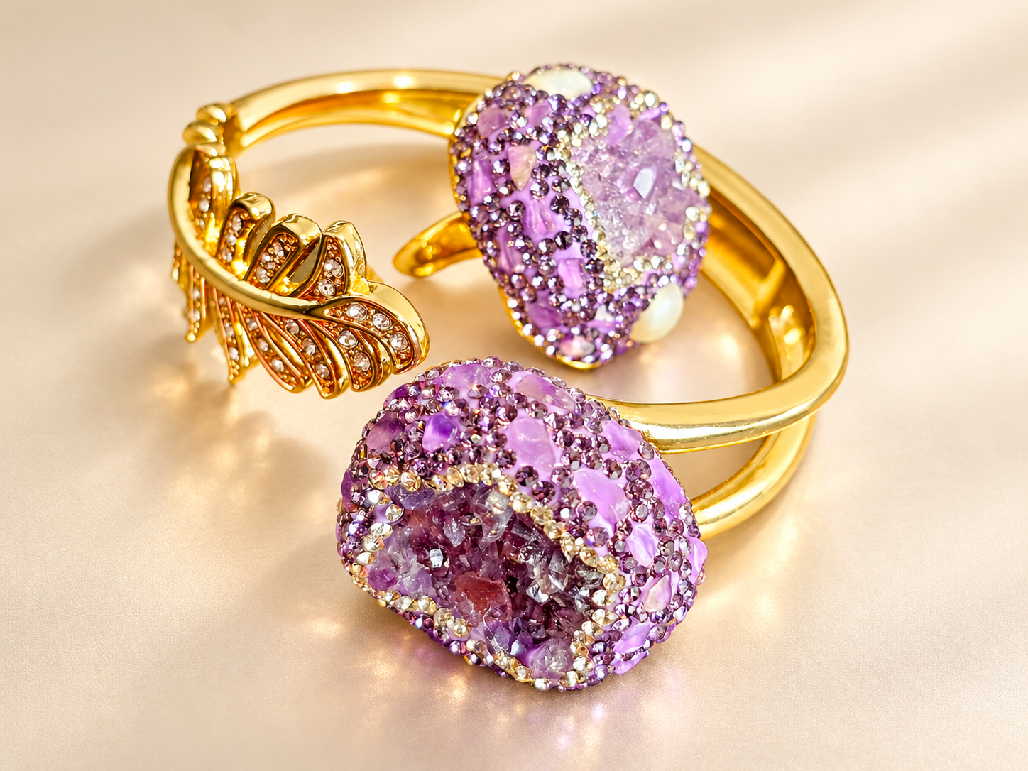 Parure Violette Minérale — Bracelet à double ligne dorée au premier plan et bague dressée à l’arrière, ornés de fragments lilas et de petits éléments brillants violets.
