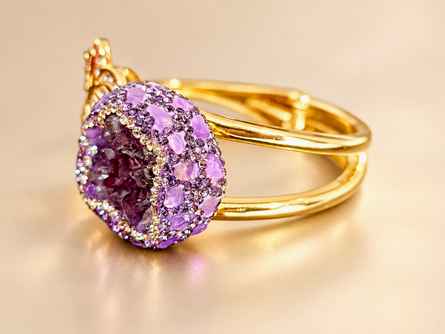 Bracelet de la parure Violette Minérale — Bracelet de la parure vu de trois quarts, avec deux lignes dorées et un grand décor ovale violet bordé de petits éclats clairs.
