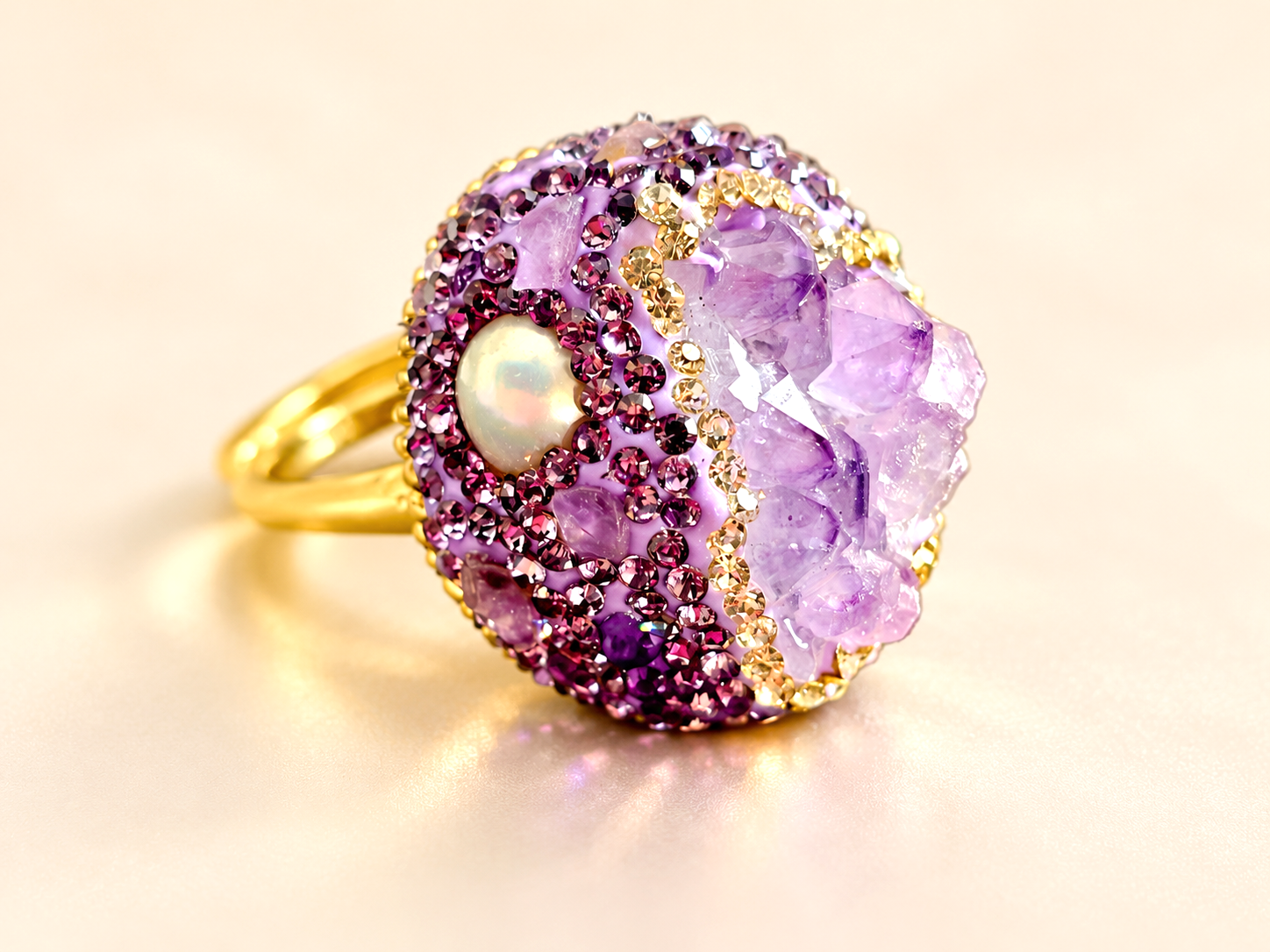 Bague de la parure Violette Minérale — Gros plan latéral du décor de la bague, avec une touche blanc perlé, des éléments brillants prune et des fragments lilas bordés d’éclats champagne.