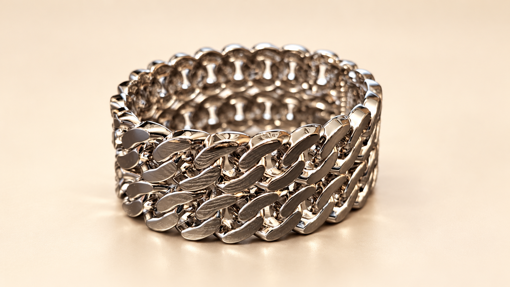 Bracelet Manchette Entrelacs Argentés — Bracelet large vu de trois-quarts sur fond clair, avec plusieurs rangées de maillons entrelacés brillants et un intérieur ajouré.