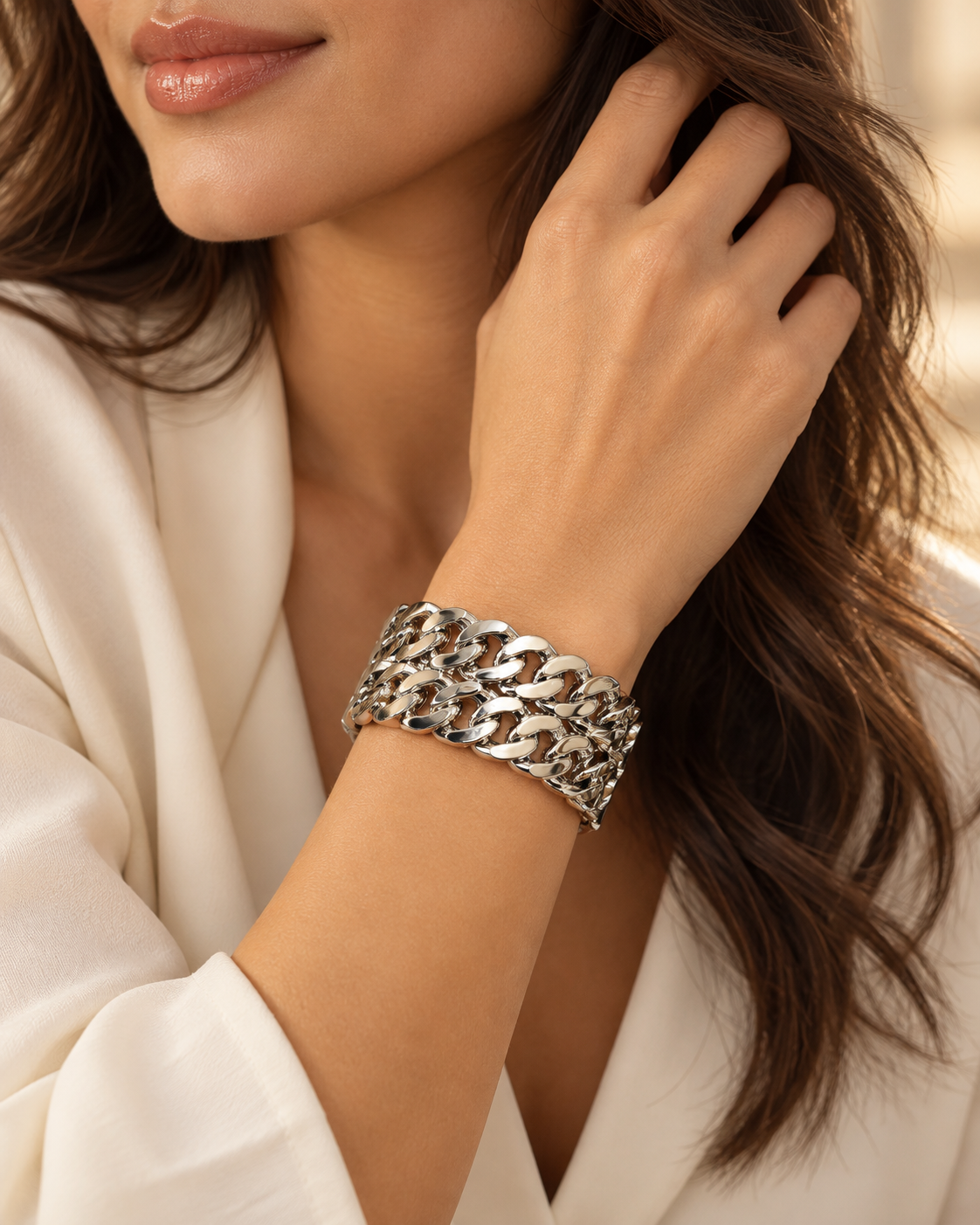 Bracelet Manchette Entrelacs Argentés — Bracelet porté seul au poignet, montrant la largeur du motif ajouré et les reflets clairs des maillons aplatis.