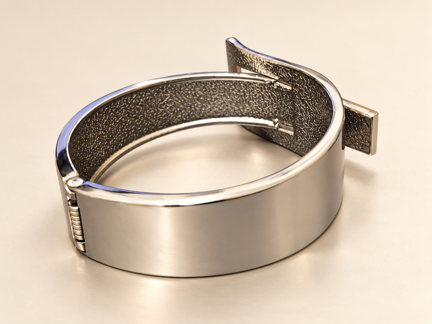 Bracelet Manchette Passage Argenté — Dos lisse et réfléchissant de la manchette argentée, charnière à gauche et surface intérieure texturée visible en plongée.