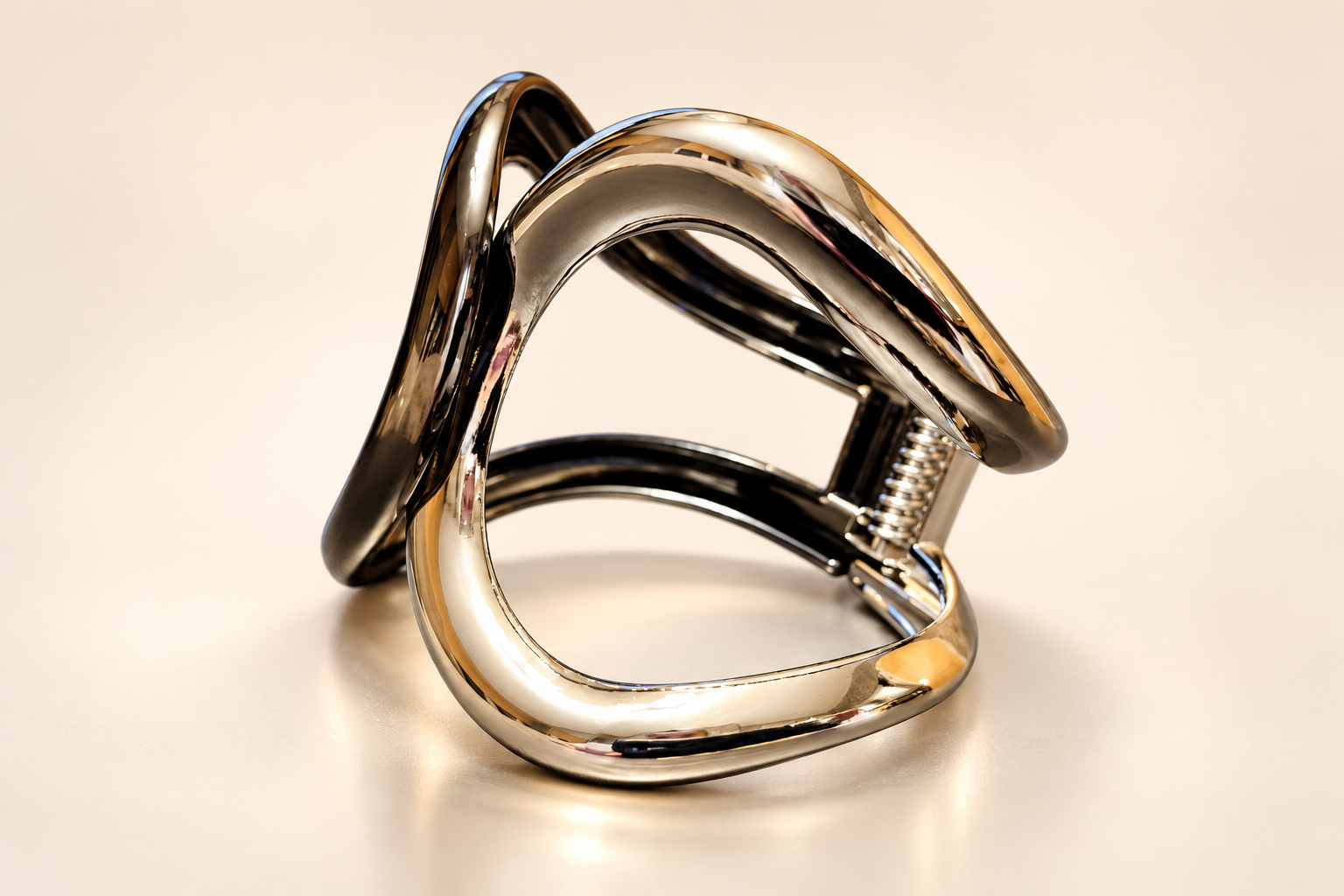 Bracelet Manchette Arabesque aux Courbes Miroir — Bracelet de trois-quarts sur fond clair, lignes bombées très réfléchissantes, structure ajourée et ressort latéral à droite.