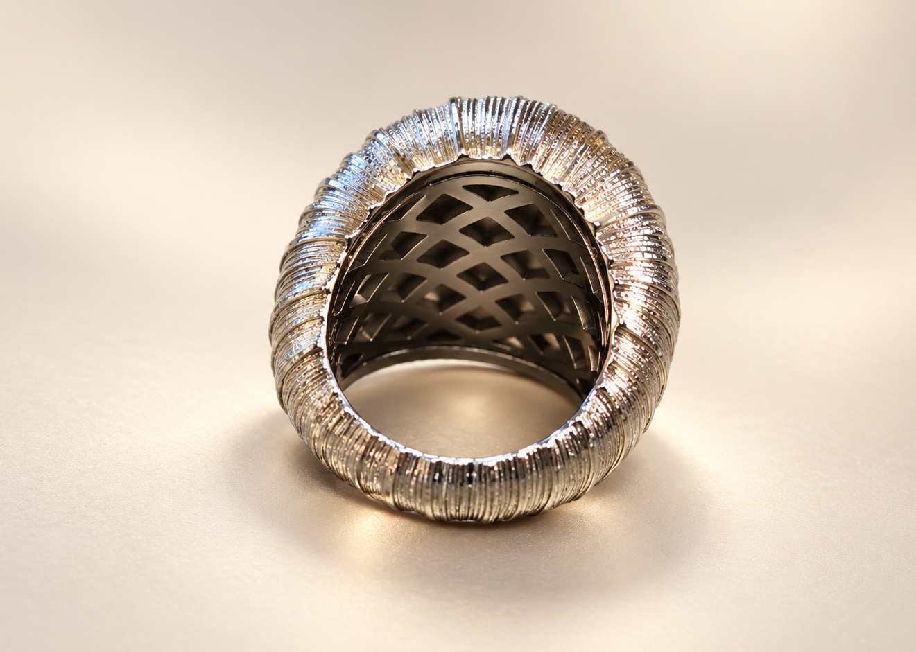 Bague Sillage Bombée Argentée — Intérieur de la bague avec ouvertures géométriques sous le dessus bombé et contour argenté strié.