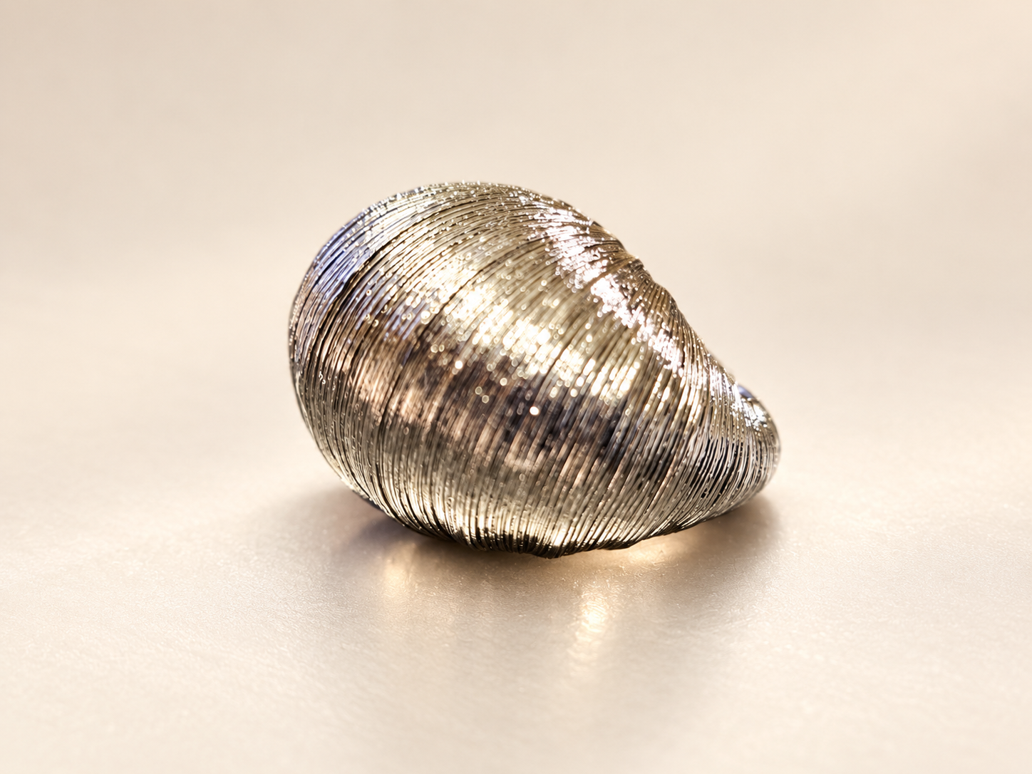 Bague Sillage Bombée Argentée — Vue extérieure de trois-quarts de la bague argentée, soulignant les stries serrées et le rétrécissement vers la base.