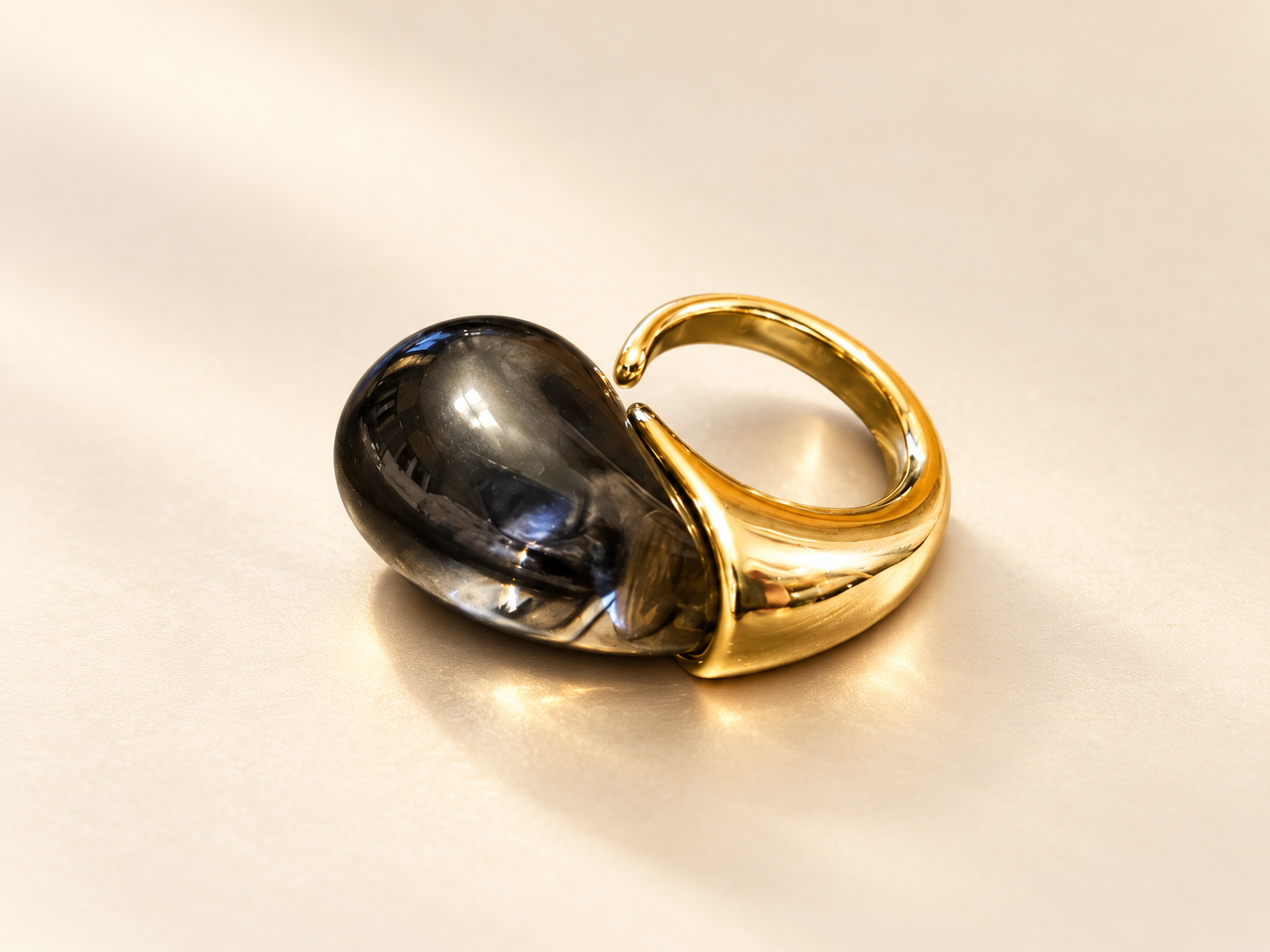 Bague Brume Cabochon Fumé — Bague vue de côté montrant l’épaisseur du cabochon sombre et la monture dorée évasée qui en accompagne la base.
