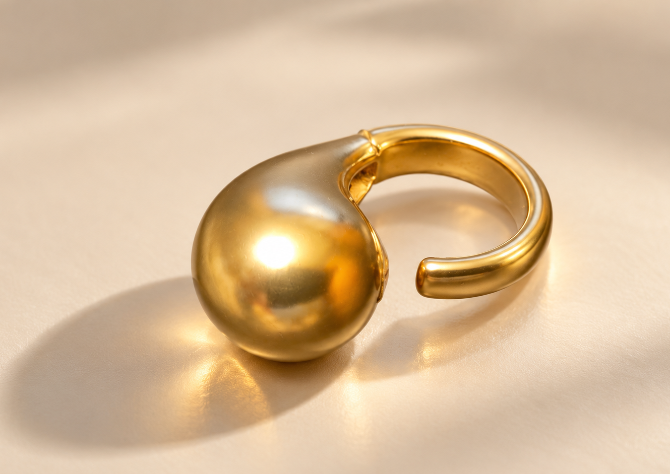 Bague Fluidité Goutte Bombée — Doré — Bague doré de trois-quarts, goutte bombée au premier plan et anneau ouvert à droite sur fond clair.