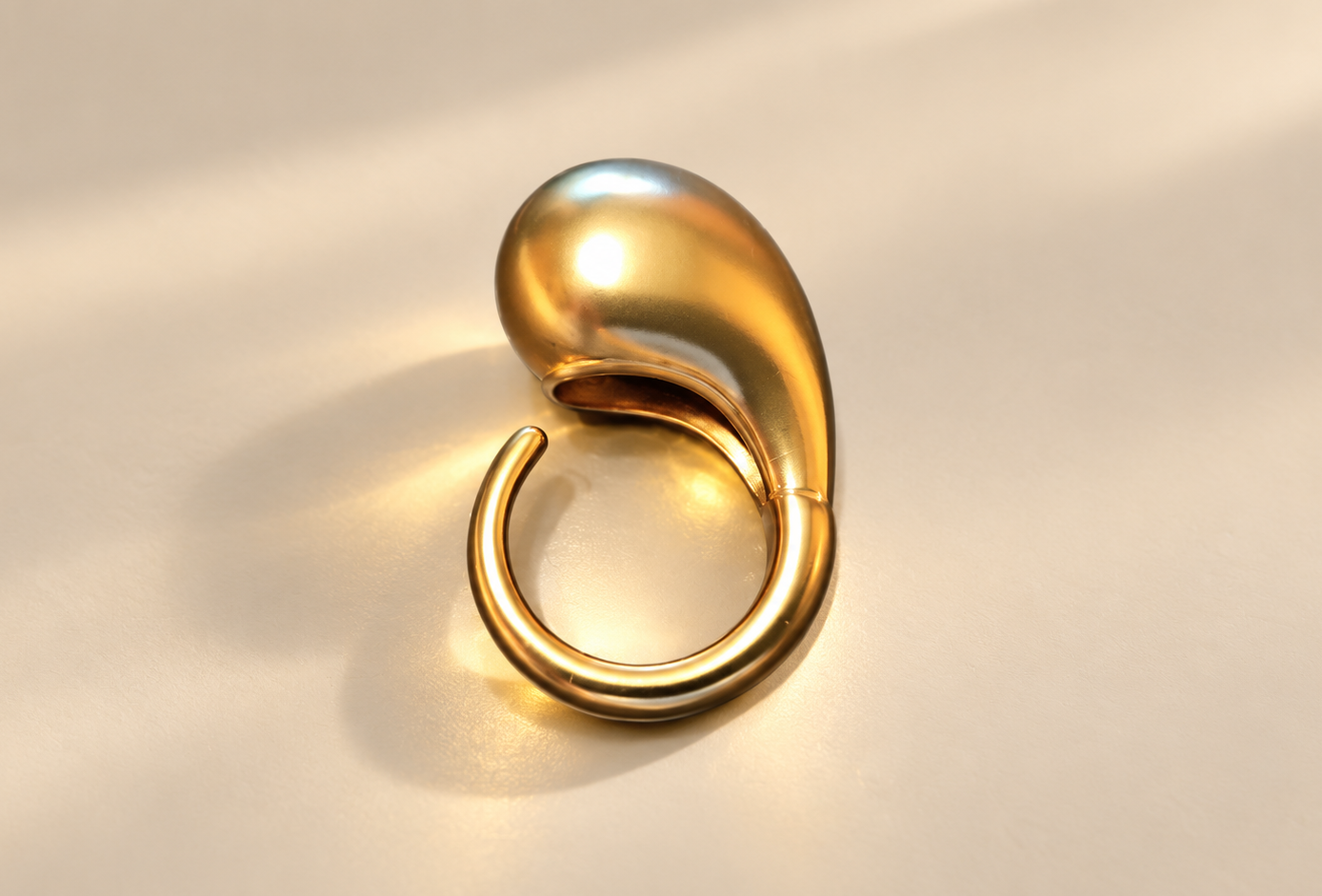 Bague Fluidité Goutte Bombée — Doré — Bague doré disposée verticalement, goutte effilée en partie haute et anneau ouvert en partie basse.