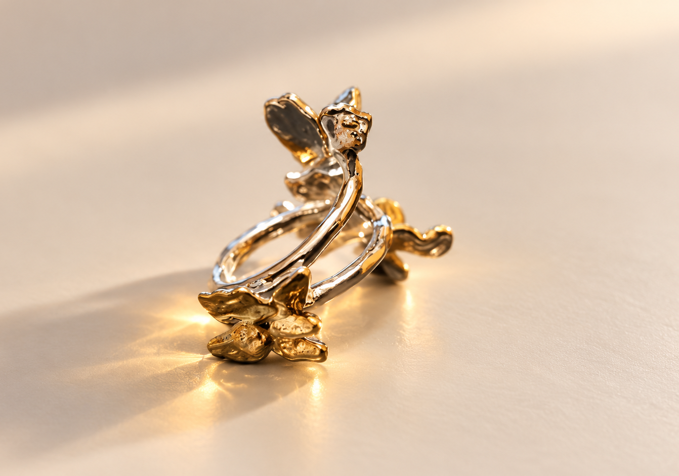 Bague Envol aux Papillons Dorés | Argenté — Bague vue de côté, ailes texturées relevées et structure ajourée aux reflets argentés et dorés.