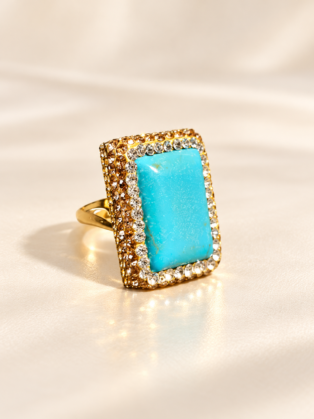 Bague Horizon Rectangle Bleu — Bague inclinée de trois-quarts, montrant le relief du cabochon bleu, les bordures brillantes et une épaule ajourée de l’anneau doré.