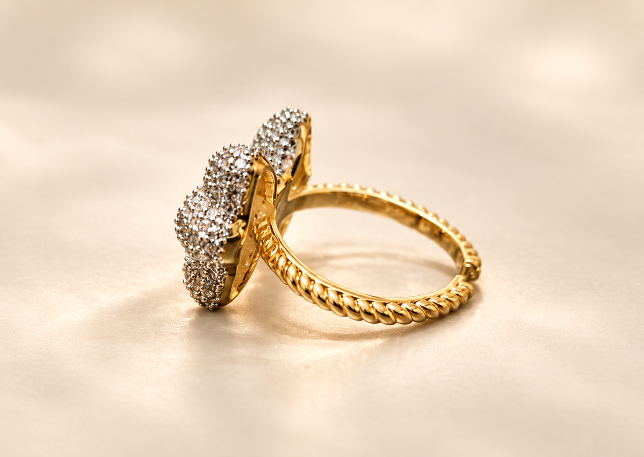 Bague Révérence Nœud Scintillant — Vue latérale du motif surélevé, avec son support doré et l’anneau au relief torsadé nettement visibles.